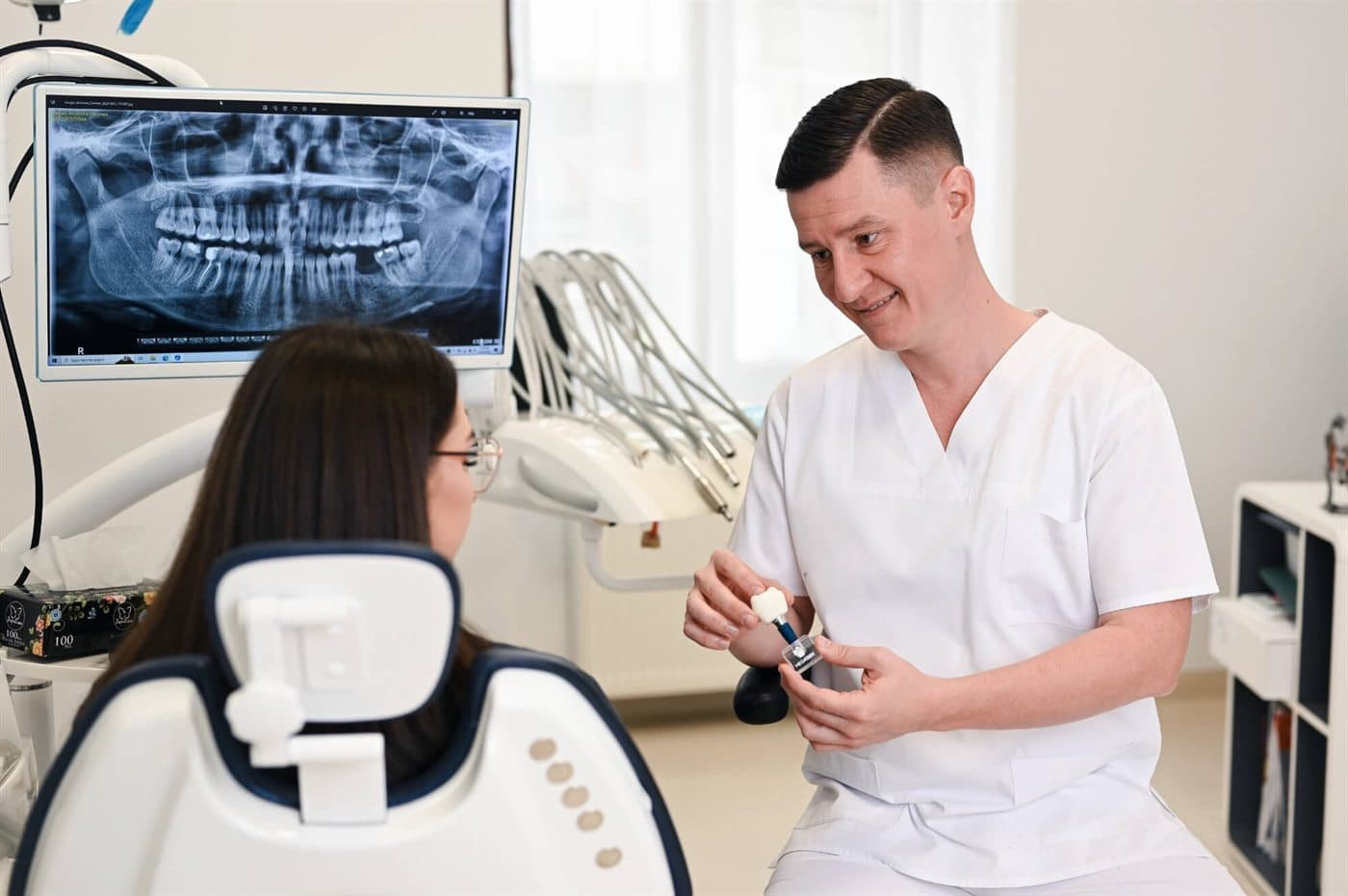 Dentist explaining a dental implant to a patient at our partner clinic