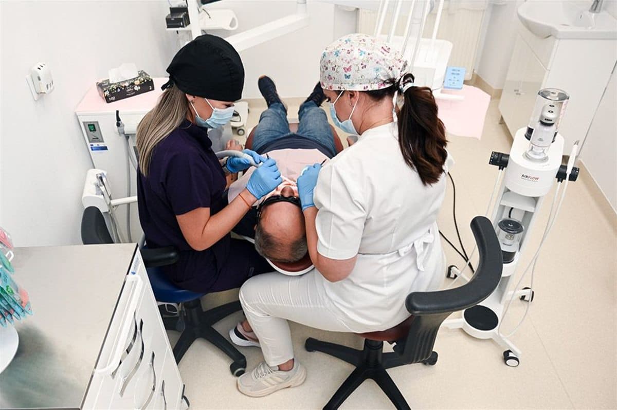 Zahnärztliche Fachkräfte behandeln einen Patienten in unserer Partnerklinik in Satu Mare